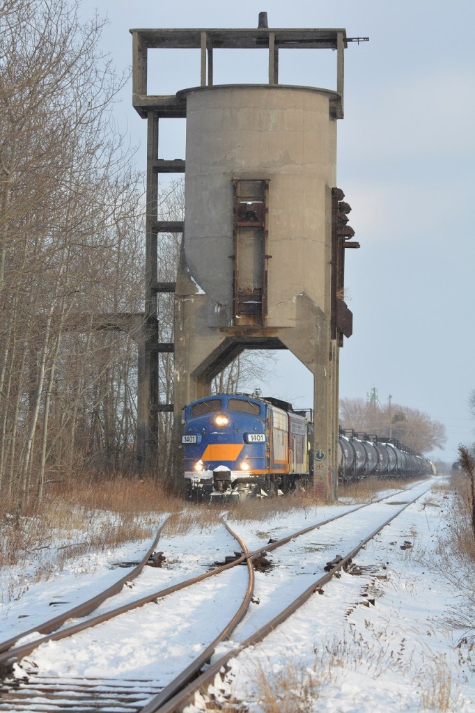 Setting off one final tank car for storage and allowing the previously cloudy skies to open up, the pair of F units momentarily pause under the old coaling tower