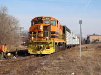 With their work complete in Guelph along with switching the Guelph North spurs, the engineer briefly steps down to close the switch off the mainline. Once the brakeman is back on board the train will begin its journey back to Cambridge. In the background is the former CN freight house and maintenance building now being redeveloped. Some of the old switches to the building are still intact.
