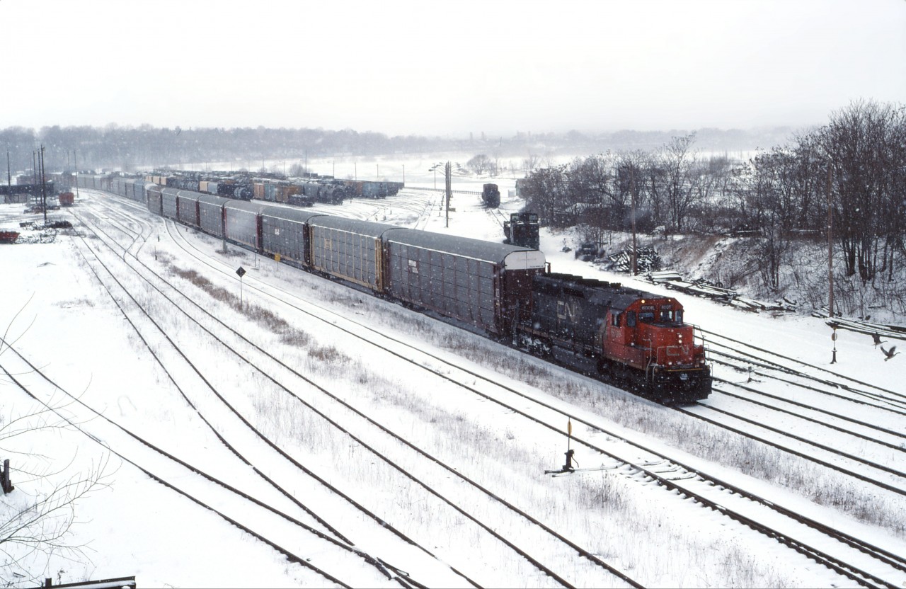 Ten years to the day after the Chessie System photo in Hamilton, we see the regular Oakville-Buffalo, NY auto train pass through a snowy "steel city". Generally, the power and crew would originate/terminate at MacMillan Yard and run light between there and Oakville Yard. Normal power was a single SD40u; however, occasionally a pair of GP40-2LWs would be used. In the 2000s, this train was renumbered 431 and ran with an SD75I or C44-9W.