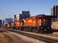 The collapse of the Cainsville fill on May 20, 1986 necessitated re-routing the steel train over the Welland sub. Here we see a trio of C424s leading it past the TH&B station in downtown Hamilton.