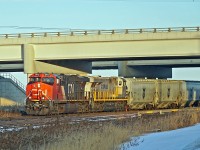 A pair of ES44ACs, CN 2972 and CREX 1517 bring a train of P & H hoppers through Clover Bar.