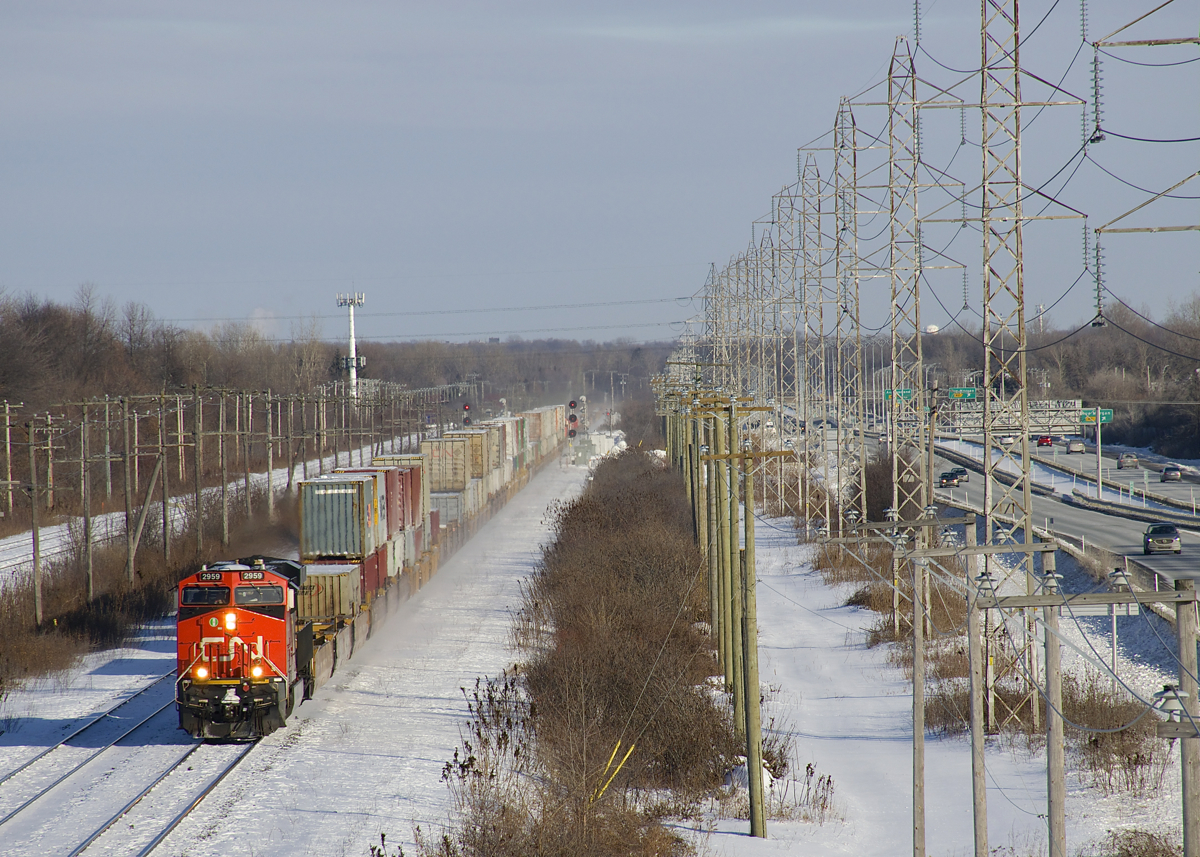CN X121 has CN 2959 leading and CN 2334 51 platforms back as it heads west on CN's Kingston Sub with 130 platforms, including 81 empties.