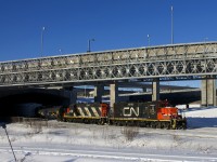 The Pointe St-Charles switcher is eastbound as it passes under the rapidly changing Turcot Interchange in Montreal with GP9's CN 7054 & CN 4115 for power and cars for Pointe St-Charles Yard. 