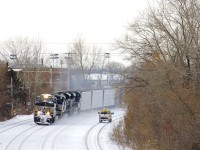 CN 528 with NS 9942, NS 7306, NS 2773 and 62 cars rounds a curve on the north track of CN's Montreal Sub as a foreman heads in the opposite direction on the transfer track.