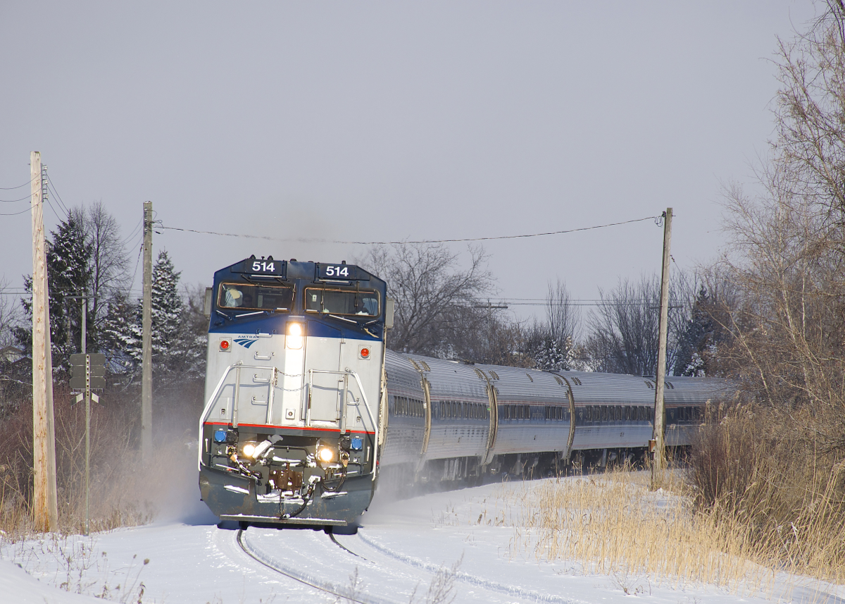 AMTK 68 with AMTK 514 leading rounds a curve in Brossard, approaching MP 36 of CN's Rouses Point Sub. Out of sight at left is the Massena Spur, now a line that serves a handful of local customers, but was once a through line to its namesake city of Massena, NY.