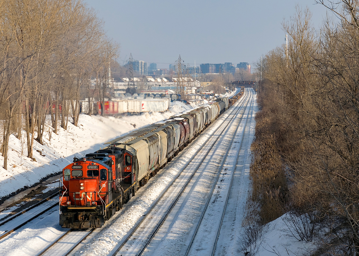 GP9's CN 7017 & CN 7228 are on their way to nearby Taschereau Yard with a mix of mostly empty grain cars and baretables (436 axles total) as they pass through Lachine during a brief sunny stretch this afternoon.