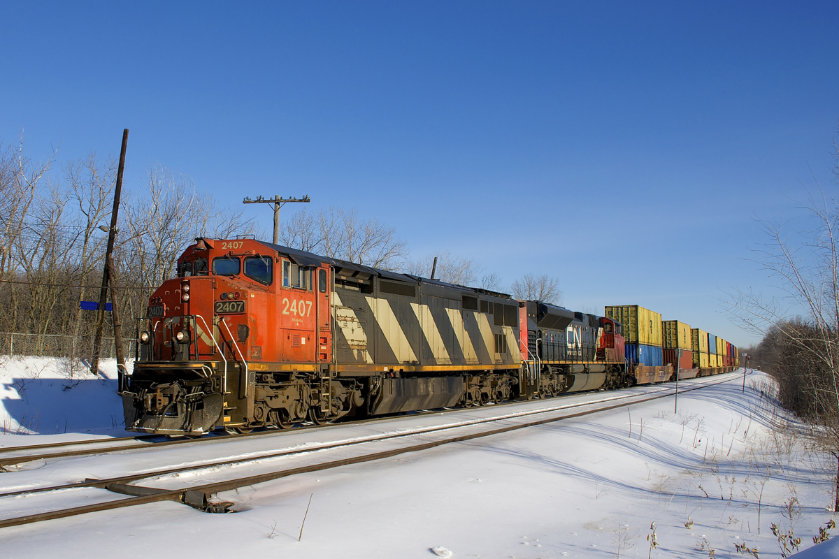 CN 2407 & CN 8813 lead a shorter than usual CN 149 (368 axles) around a curve just past MP 22 of CN's Kingston Sub on a sunny morning.