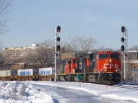 A couple of days after a large amount of freezing rain coated the remaining snow in Montreal, uncleared fields and paths are a real skating rink. Here CN 120 passes some of this ice-covered snow with CN 3077, CN 5733 & CN 2440 for power and a 514-axle long train as it splits the signals in the St-Henri neighbourhood of Montreal.