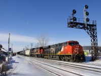 CN 372 has ES44AC CN 2922 (built in 2014) and Dash8-40C CN 2128 (built in 1991) as head end power as it passes under a signal gantry at Dorval as the train crosses from the north track to DX-1 track. Mid-train is CREX 1501, an ES44AC built in 2015. Trailing unit CN 2128 wears a logo commemorating the 15th anniversary of CN's privatization, which took place in 1995.