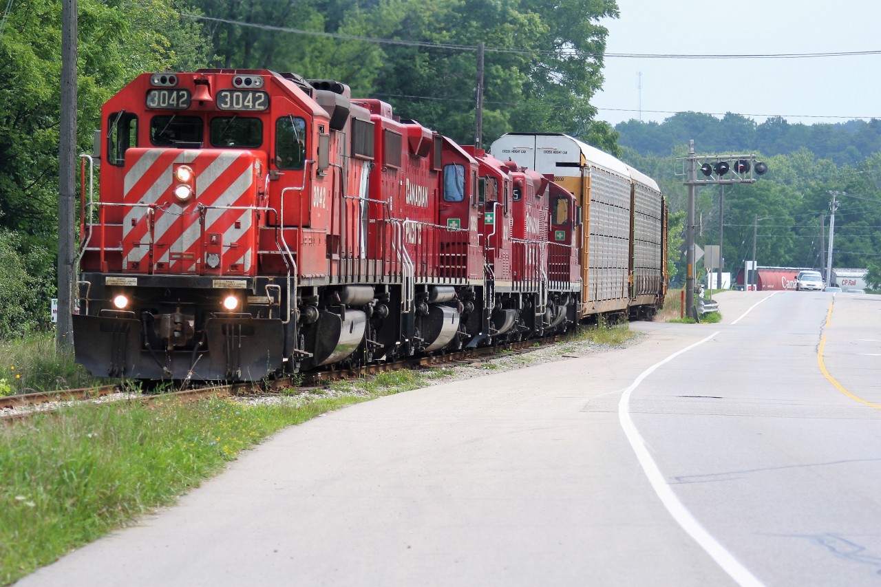 A quartet of four-axle power including; GP38-2’s 3042, 3032, GP9u’s 8212 and 8215 lead a lengthy train into Kitchener on the Waterloo Subdivision destined for the interchange with the Goderich-Exeter Railway on a hazy summer afternoon.