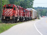 A quartet of four-axle power including; GP38-2’s 3042, 3032, GP9u’s 8212 and 8215 lead a lengthy train into Kitchener on the Waterloo Subdivision destined for the interchange with the Goderich-Exeter Railway on a hazy summer afternoon. 

