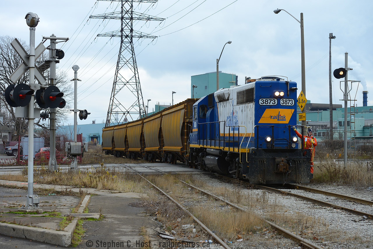 There's prototype for everything. Witness this strange move: SOR Conductor Lance Brown eases cut of unpainted steel hoppers across Beach Ave in Hamilton. These cars were lifted from National Steel Car to be put into storage on the former Stelco Bar Mill's tracks in Hamilton's industrial basin which were used for car storage at the time. NSC was a busy place and within a few weeks (or months) these cars were sent in for painting and shipped out.

Lots of details here also - notice the white (flashing) signal? These were installed by the TH&B as this lead  is used for CP for the TH&B (now CP) Adams yard and these flashing signals are found on most of the CP/TH&B Maintained crossing signals in the area. The track in foreground is the former CN Ore Train lead - Dofasco ore trains would have reversed (heading behind the photographer) to Dofasco to unload ore and making the reverse move back through here, to the Lysaught lead (wye by Dofasco Central Shipping in distance) back onto the Grimsby sub at Parkdale yard destined for  the Newmarket sub and Temagami Mine on the ONR for reloading. The Ore train lead also hosted Dofasco engine movements until 2012 or so once or twice a week - now ended. In the far distance there was a fourth track crossing as part of this circuit - which was a Dofasco only track for internal switching moves - remnants exist but it was a long time ago that you had Dofasco, CN and CP tracks  with  switchers crossing here dozens of times a day. In contemporary times you can find SOR and CP here a few times a day as it's basically all joint track (both railways retain access) - don't hesitate to visit here when fishing for locals in Hamilton, your chances are usually pretty good.
