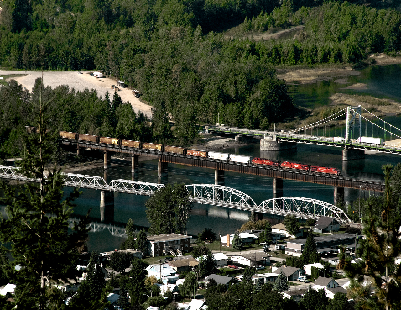 Grain empties just off Eagle Pass crosses the Columbia River before entering Revelstoke. TCH bridge on Right and city bridge on left