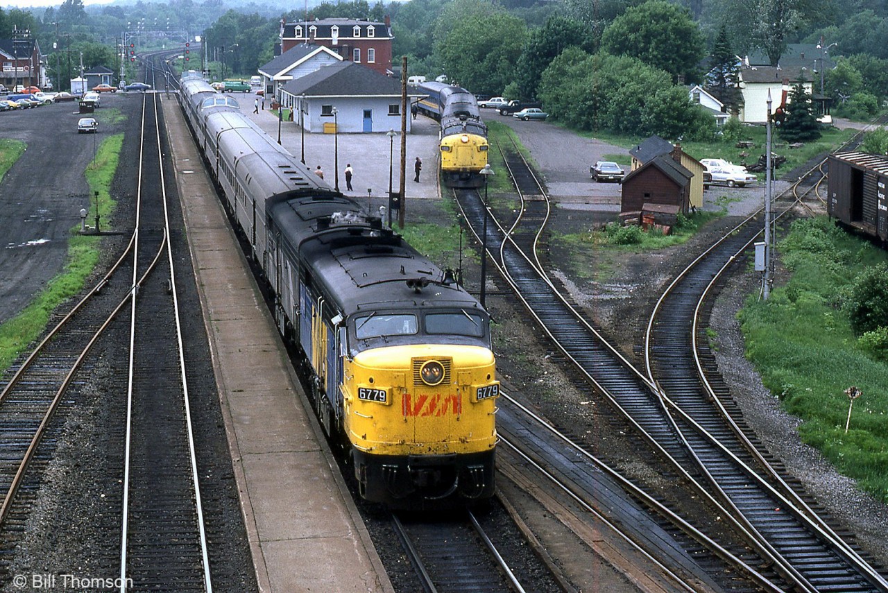 VIA Rail train #54 (lead by FPA4 6779 and an FPB4) and train #44 (with FP9 6526 on point) are both waiting to depart from Brockville station for Montreal & Ottawa respectively, on June 1st 1982. Note the stainless steel dome cars in #54's consist - this was when VIA's Canadian was was added to #54 to carry on to Montreal. The trailing FPB4 is likely either 6866 or 6867, both of which lasted longer that the others in CN zebra stripes (6866 lasted until retirement and was never repainted VIA).