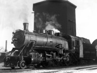  During visits to my grandmother on the CP main,as a 9 year old with a Kodak Brownie camera,I gravitated down to the station and photographed everything that would show up. In this shot an ubiquitous D-10 4-6-0 on a westbound Hi-Wide special pulls up to the water tank west of the station 
