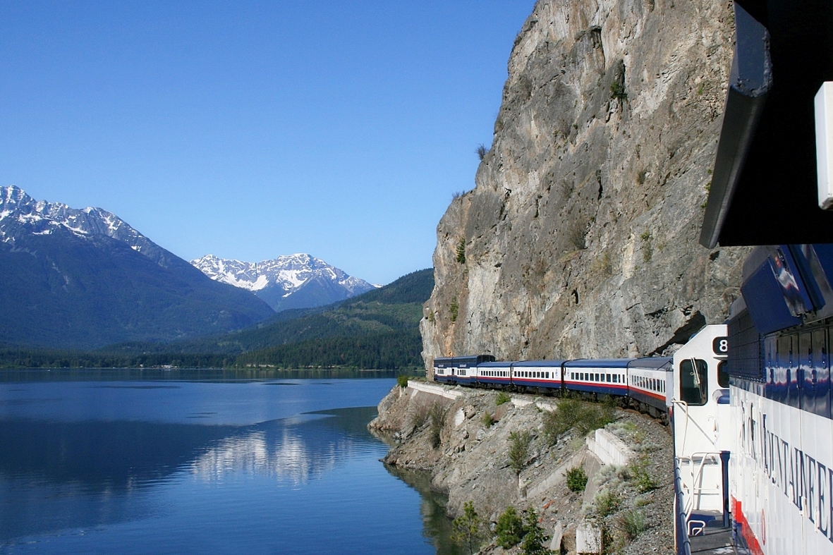 Running along Anderson Lake on our northward journey on the former BC Rail the train is sneaking along the "dry slide", the terrain is rugged straight up and straight down. I could hear the "ohs and ahs" of the passengers enjoying this spectacular scenery. The locomotive is at mile 126 and this area has a 15 mph speed restriction "until track is seen to be clear". Most crews approached this area at about 10 mph. The curve behind the dome car is a tight 13 degree.