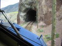 Heading north on the RMR Fraser Discovery with a hazy sky account forest fires. A short tunnel at mile 168.39 and view of the slide /rock fall fencing that has been placed in various areas on the treacherous piece of terrain known on BC Rail as "Kelly Lake Hill". Most trains still have a track patrol running ahead of them despite the electronic fencing along the way. Crews must remain vigilant for errant rocks that intercede the track patrols and slide fences. On the left of this view is the Fraser River, a long long way down the hillside. All very scenic for the "paying passengers" riding this train, still a tense passage for the crews that negotiate this track on a daily basis.