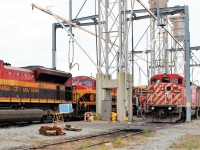 Kansas City Southern power occupies track 7 at the fuel stand while in transit to new owner Central Maine & Quebec is former CP Rail red barn 9004 on track 8.