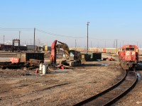 The setting at the end of the day shows the pile of cooling and dynamic braking fan covers from the 5835 and the previous 2 SD's that were dismantled here. In front of the excavator are a bunch of car body doors and various cut up parts.
