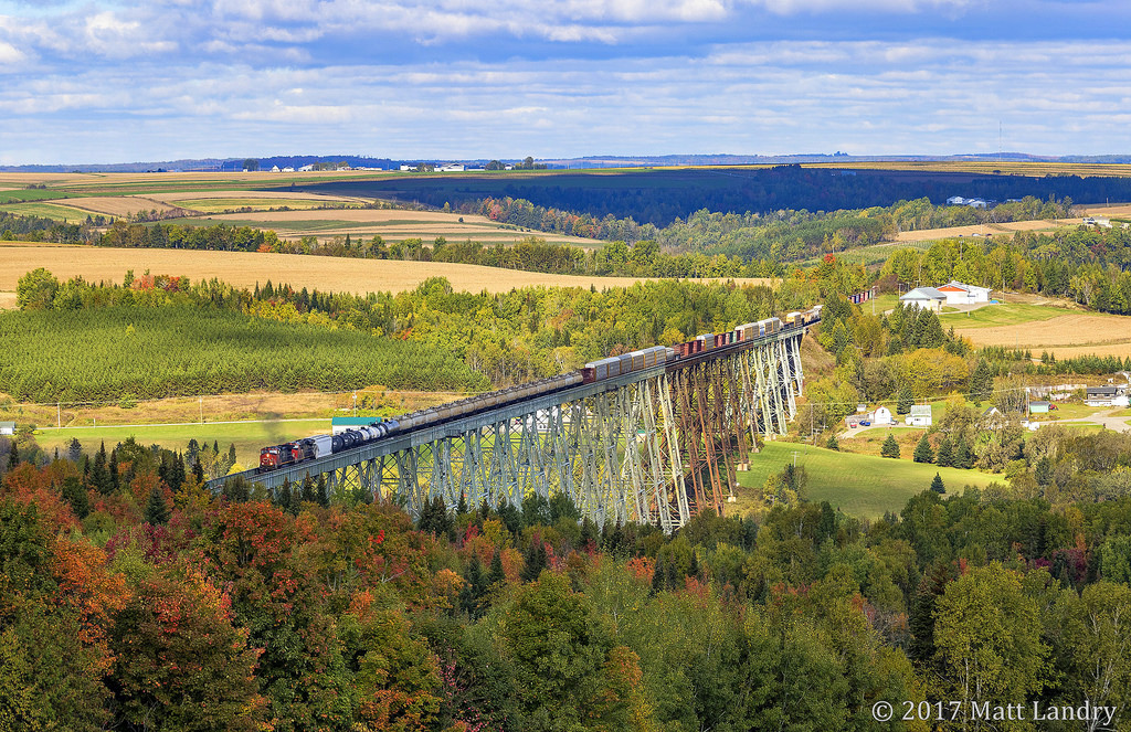 CN 2665 leads an X474 eastbound, as they cross the 3,920 foot Salmon River Trestle in New Denmark, New Brunswick on a cool Fall afternoon. The leaves are just starting to change color in this area. A week later, there would have been a beautiful display of Fall's colors.