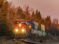 CN 3018 leads stack train Q120, as they head into the sun at East Mines, approaching Debert, Nova Scotia. 