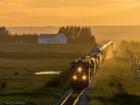 With the sun nearly set for another summer day, casting a great yellow glow, eastbound train 408 heads by Fort Lawrence, as they approach Amherst, Nova Scotia. 