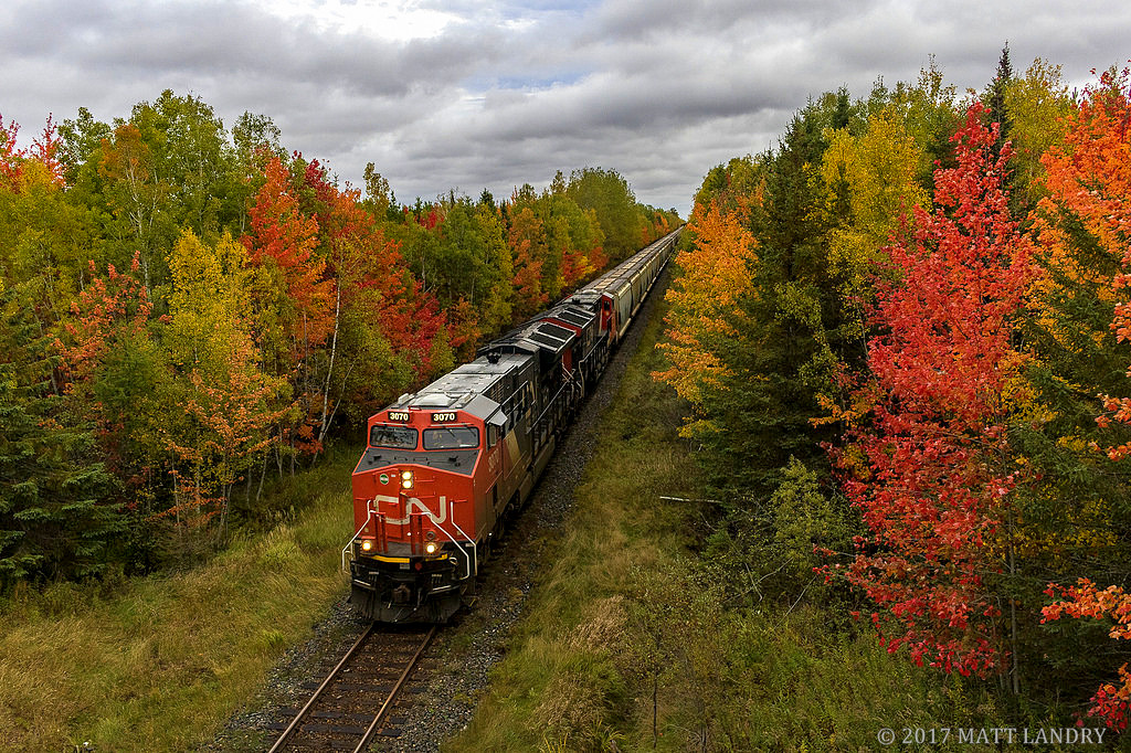 CN 3070 leads a potash train through nice Fall colors, approaching Petitcodiac, New Brunswick.