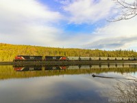 The sun has just peeked over the hill side, as CN B730 heads by "The Lake", as they start their descent down into Saint John, New Brunswick. 