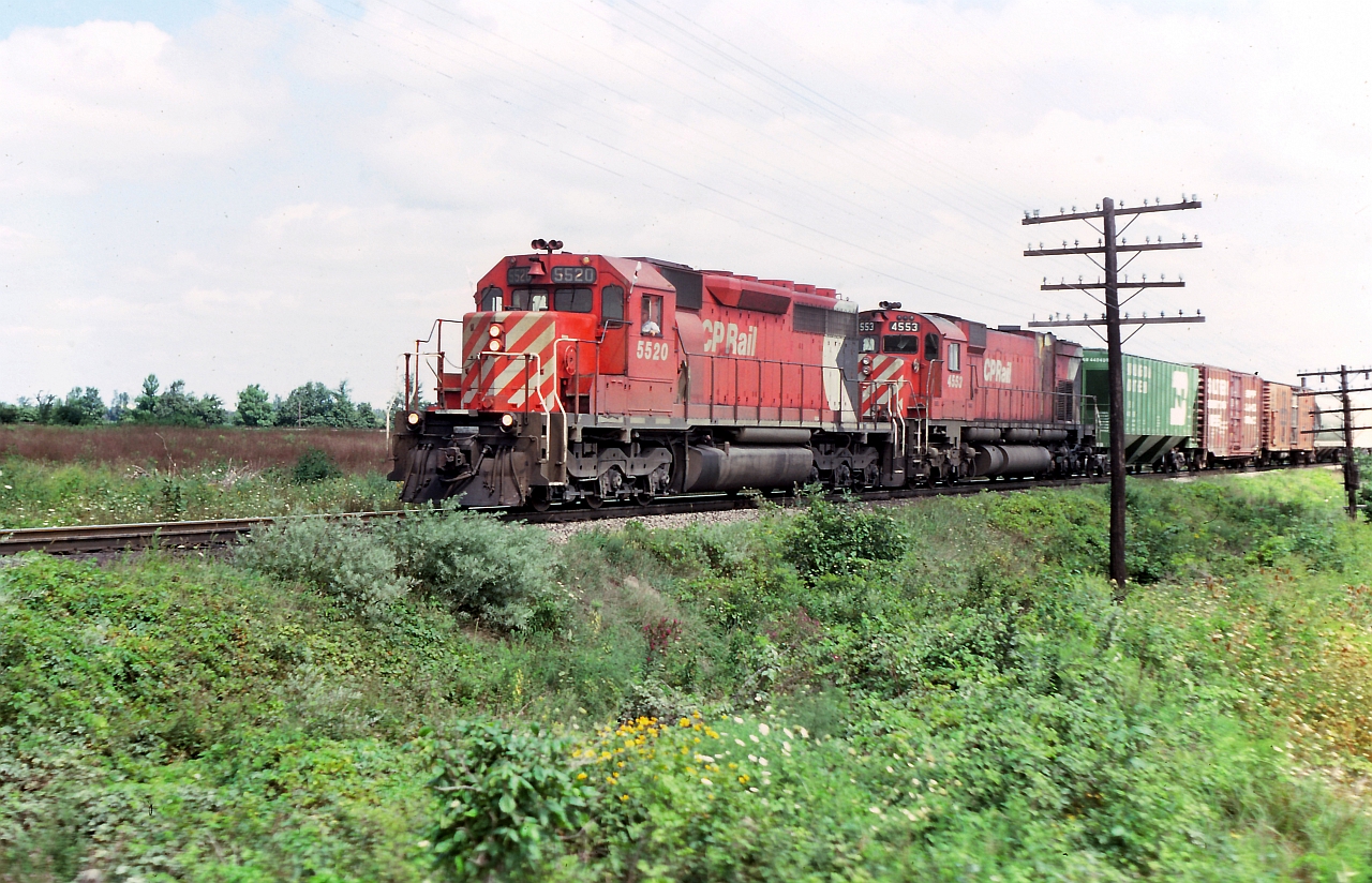 A hot summer afternoon long ago. CP 5520 & 4553 a west bound through the crop fields of southwestern Ontario.