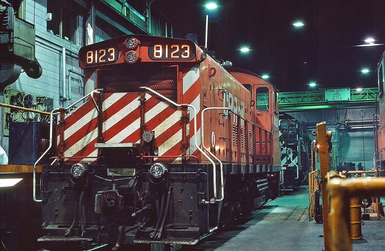 CP Rail #8123 inside the CP Rail  Agincourt Diesel Shop.


Kodachrome taken during an escorted (CP Rail permission granted) shop tour.


#8123 is one of 72 GMD SW1200RS built 1958 – 1960 for the CPR; 


33 SW1200RS units were rebuilt to SW1200RSu standards (replacing the 567 engine with a 645) in 1981 – 1985 however #8123 not in that program. #8123 sold to Helm Leasing April 1998.


at the CP Rail Agincourt Diesel Shop December 15, 1984 Kodachrome by S. Danko


what's interesting


ya gotta luv those candy stripes