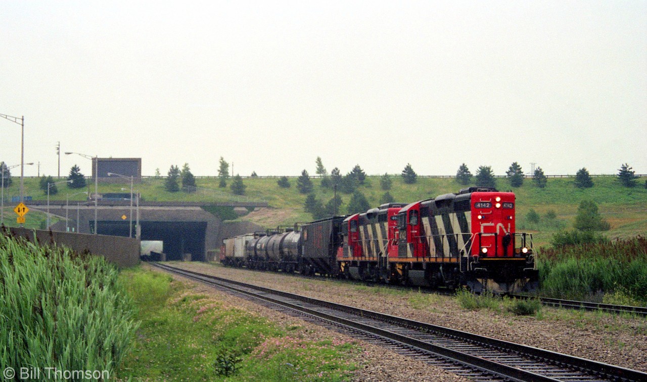 CN GP9RM 4142 and another sister rebuilt geep haul a short train westbound on the Stamford Sub, pictured coming out of the west side of the Welland Canal.