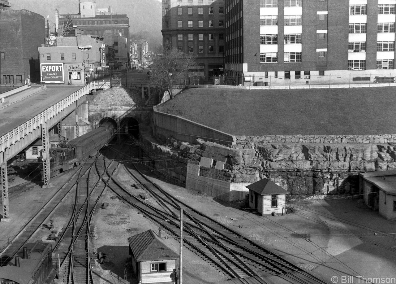 Here is a view of the trackage at CN's Central Station (Gare Centrale) in Montreal in 1952, showing the entrance to The Mount Royal Tunnel. An electric train (lead by one of CN's three 200-series Z5a GE steeplecab electrics, later renumbered 6725-27) is seen exiting from the north, and CN SW9 7007 waits at the lower left. Several examples of switches (turnouts) are shown, including double slip switches, double crossovers, diamonds, etc. This whole area is now under Place Ville Marie, and the old tunnel entrance pictured here is now under the present day intersection of Avenue McGill College and Rue Cathcart.