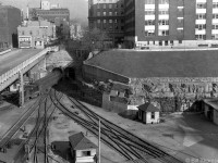 Here is a view of the trackage at CN's Central Station (Gare Centrale) in Montreal in 1952, showing the entrance to The Mount Royal Tunnel. An electric train (lead by one of CN's three 200-series Z5a GE steeplecab electrics, later renumbered <a href=http://www.railpictures.ca/?attachment_id=21764><b>6725-27</b></a>) is seen exiting from the north, and CN SW9 7007 waits at the lower left. Several examples of switches (turnouts) are shown, including double slip switches, double crossovers, diamonds, etc. This whole area is now under Place Ville Marie, and the old tunnel entrance pictured here is now under the present day intersection of Avenue McGill College and Rue Cathcart.
