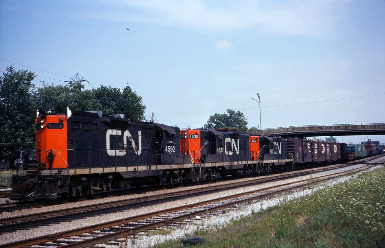 Into the early 1980s, GP9s were common power on CN freights to and from the Niagara peninsula. In this photo, we see Fort Erie-MacMillan Yard train 462 behind 4592, 4535 and 4527 passing Merritton station in St. Catharines.