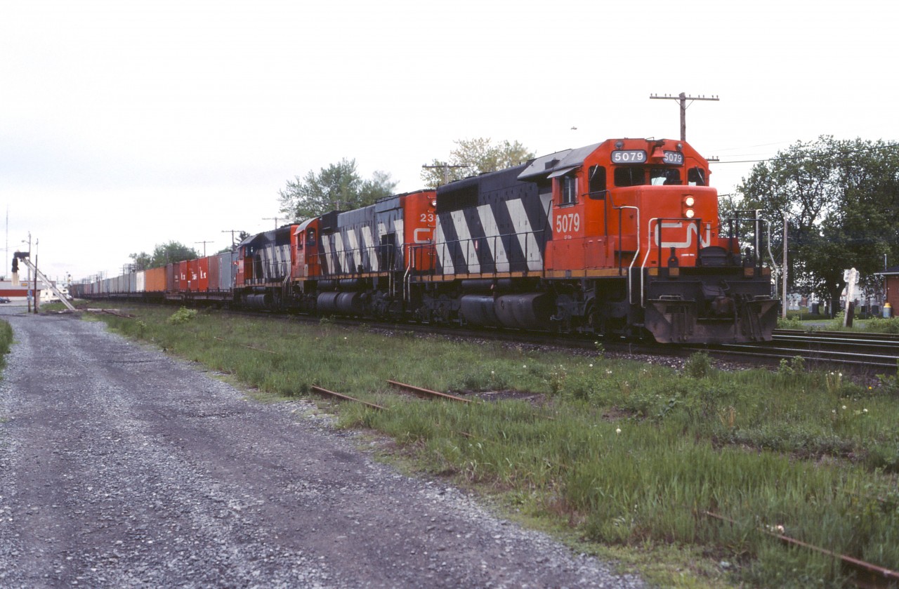 CN 208 rolls through Coteau with SD40 5079, M636 2336, and SD40 5080 on its Toronto-Halifax run.