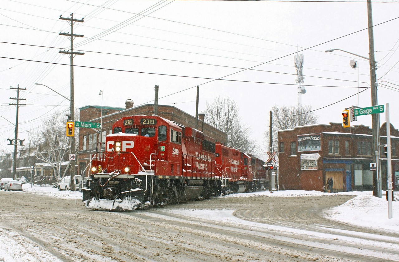 Ain't no sunshine when she snows. After chasing the Belt Line job from the North end my last location was here at Gage and Main st. I've always wanted to catch this job here but the opportunity has alluded me for some time. A few weeks prior Stephen Host caught the same job a few crossings north of this location. Note the "sandwiched" engine (in both shots) was CP 7307, an ex-D&H gp 38-2 easily distinguished by it's red frame stripe. Interestingly the orientation of the engine has reversed, which likely happened when they changed the third engine (currently gp 38-2 3118).