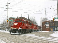 <b> Ain't no sunshine when she snows.</b> After chasing the Belt Line job from the North end my last location was here at Gage and Main st. I've always wanted to catch this job here but the opportunity has alluded me for some time. A few weeks prior <a href="http://www.railpictures.ca/?attachment_id=32111">Stephen Host caught the same job</a> a few crossings north of this location. Note the "sandwiched" engine (in both shots) was CP 7307, an ex-D&H gp 38-2 easily distinguished by it's red frame stripe. Interestingly the orientation of the engine has reversed, which likely happened when they changed the third engine (currently gp 38-2 3118).