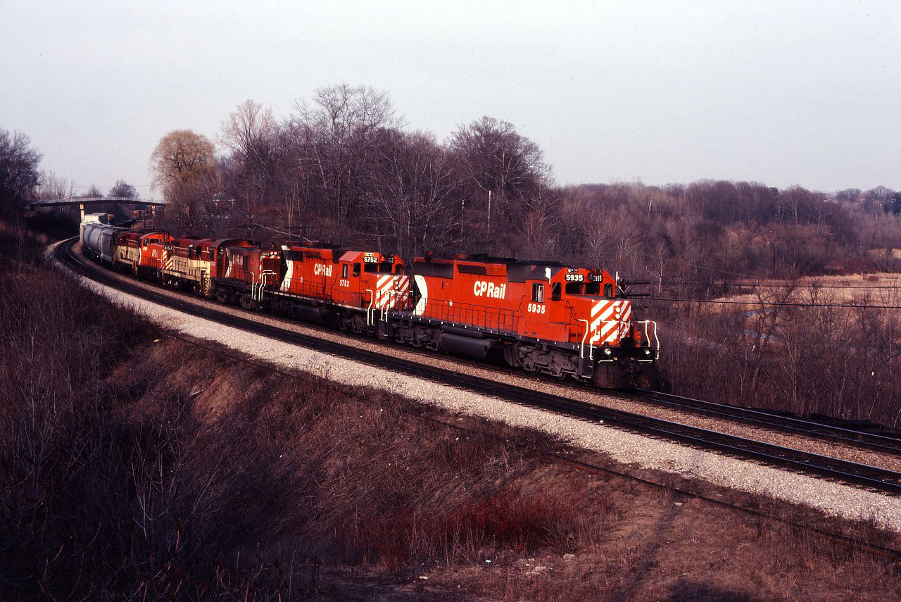 The winter of 1980-81 is over and once again a bright spring day draws us to Bayview. Our patience is rewarded as the Starlight comes around the curve with an interesting consist bound for the TH&B's Abereen yard in Hamilton. Behind CP SD40-2 road units 5935 and 5752, we have RS23 8023, GP7 76, SW1200RS 8157 and another TH&B GP7 returning from servicing at Toronto Yard.