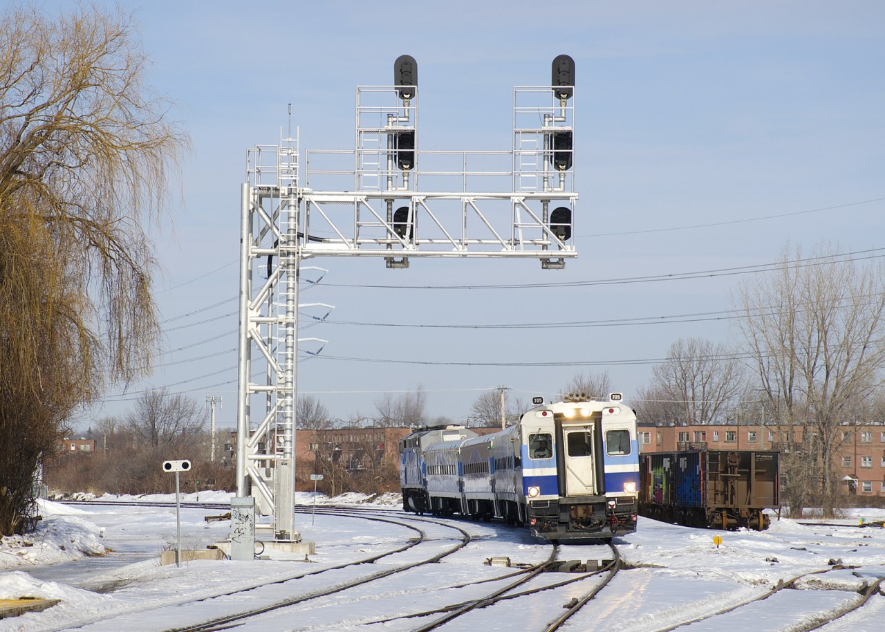 Cab car AMT 705 leads AMT 79 past CP's Lasalle Yard on a sunny afternoon.