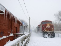 On a very snowy afternoon, CP 8800 leads loaded ethanol train CP 650 past the icicle-covered Lasalle Station. Pushing at the rear is CP 8739.