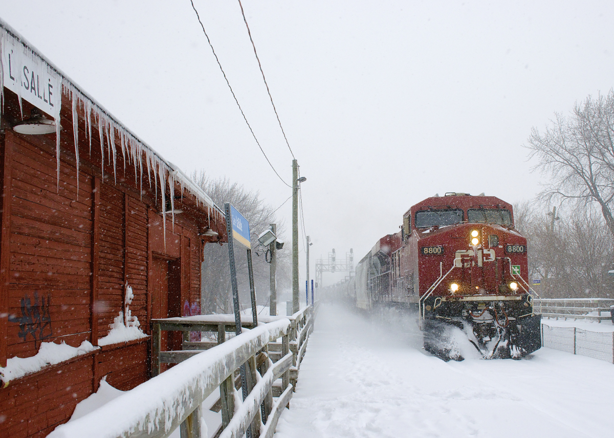 On a very snowy afternoon, CP 8800 leads loaded ethanol train CP 650 past the icicle-covered Lasalle Station. Pushing at the rear is CP 8739.