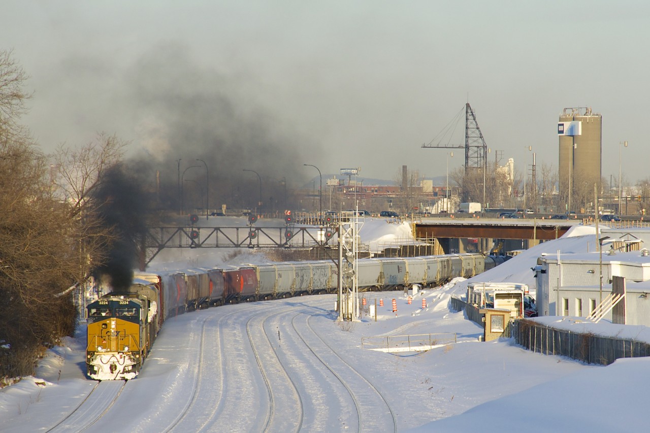 The trailing unit on CN 543 (CSXT 468) lets out a great burst of black smoke as the train heads west on the transfer track of CN's Montreal Sub, on its way to Taschereau Yard after leaving track 29 on CN's new right of way.