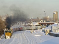 The trailing unit on CN 543 (CSXT 468) lets out a great burst of black smoke as the train heads west on the transfer track of CN's Montreal Sub, on its way to Taschereau Yard after leaving track 29 on CN's new right of way.
