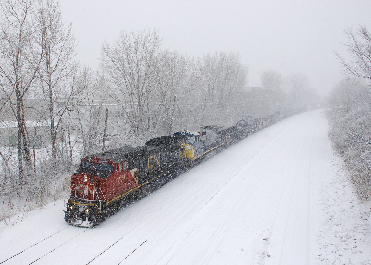 CN 2151 (built for ATSF, later becoming part of BNSF's feelt) & GECX 9142 (built for Conrail, later acquired by CSXT) lead CN 310 eastwards on CN's Montreal sub during a very thick snowfall.