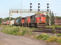 A veteran conductor on a westbound CN train comes down from his chair to confirm the approaching signal at Paris West, Ontario on the Dundas Subdivision as the high afternoon sun blazes down on his train. The elephant style consist includes; 5680/ 5738/ 2588. 