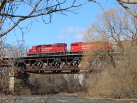 The Credit River has finally receded and the chunks of ice along the bank are finally melting away, as CP local T14 slows to work the Ardent elevator in Streetsville. In a couple of months the dormant scene here will once again begin to fill with colour as another season takes hold. 