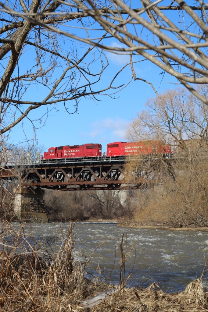 The Credit River has finally receded and the chunks of ice along the bank are finally melting away, as CP local T14 slows to work the Ardent elevator in Streetsville. In a couple of months the dormant scene here will once again begin to fill with colour as another season takes hold.