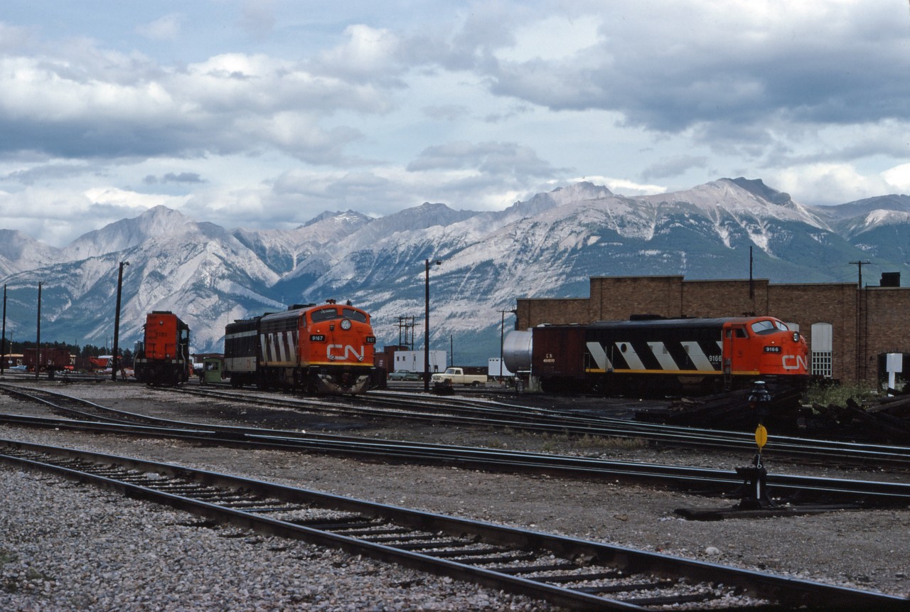 F7Au units 9166 and 9167, as well as SD40 5181, await their call to duty at the CN Jasper roundhouse in the summer of 1975. Note the Jasper auxiliary in the background.