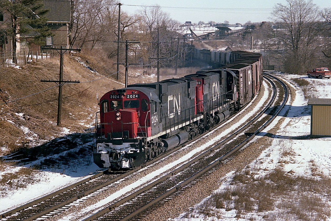 Beautiful February day some years ago, I am standing on the bridge just to the west of the Grand River trestle waiting for CN #401 west after having gotten ahead of it coming up from Bayview. Too nice a day to pass this up, and the power consisting of those big MLWs 2024 and 2000 was well worth the chase. This was the final shot of a sequence, others being at bayview and Copetown, of course.