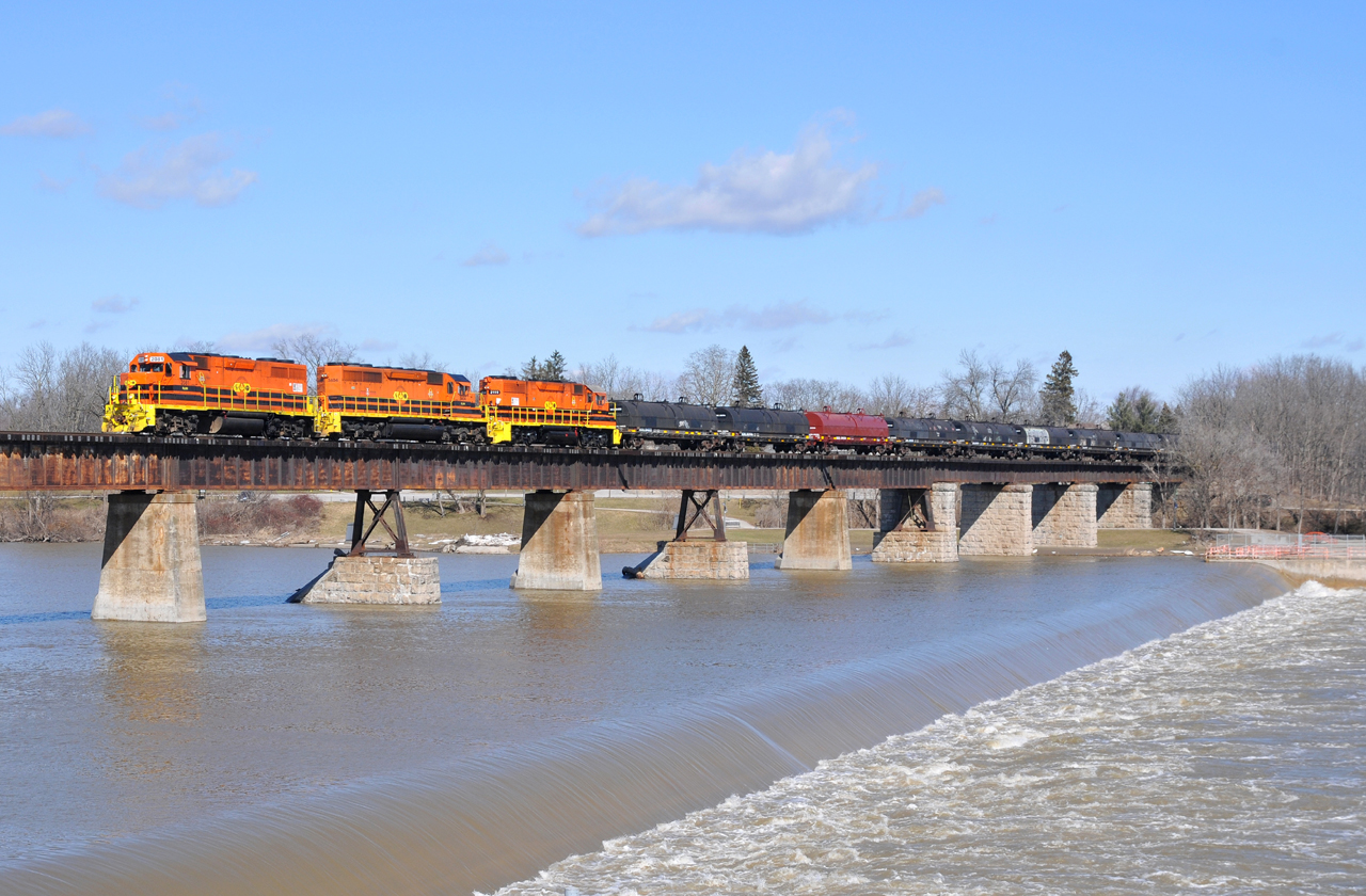 RLHH 2081, RLHH 3404, and RLHH 2111 lead a 96 car 597 (47 steel coil cars followed by 47 tanks) over the Grand River in Caledonia, ON